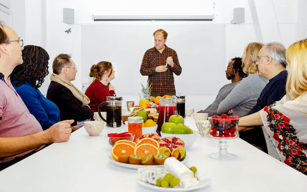 Människor sitter runt ett bord dukat med en härlig frukost